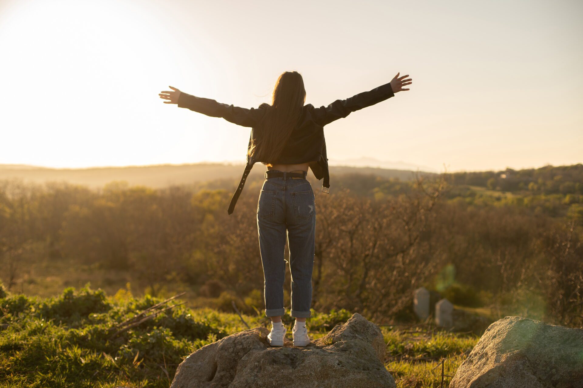 Woman with open arms in the field